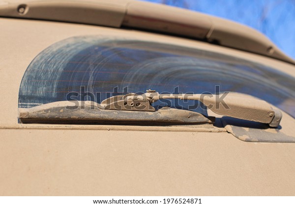 rear
windshield cleaner of a car, poorly cleaning dirt and dust
contributing to dangerous driving on a country road, the front and
background background is blurred with a bokeh
effect
