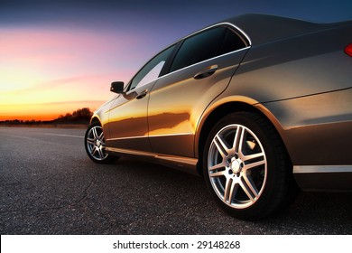 Rear-side View Of A Luxury Car On Sunset