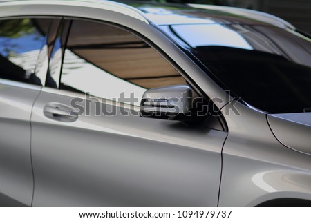 Rear-view mirror closed for safety at car park,  Side mirror of gray car , black tinted glass