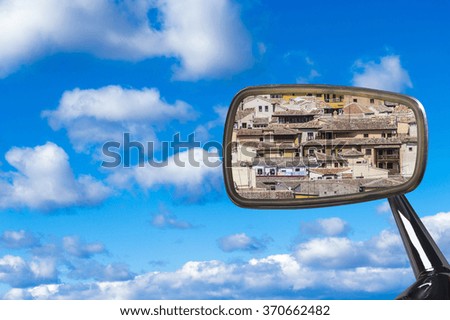 Rear-view mirror with houses on blue sky