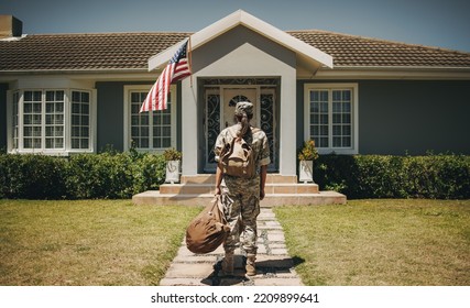 Rearview of a patriotic female soldier standing in front of her home with her luggage. Courageous servicewoman coming back home after serving her country in the military. - Powered by Shutterstock