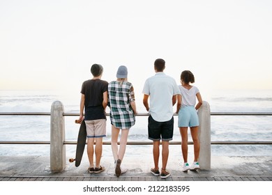 Rearview Shot Of A Group Of Young Friends Standing On The Promenade