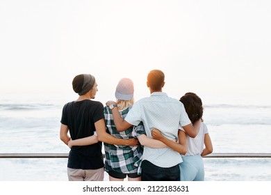 Rearview Shot Of A Group Of Young Friends Standing On The Promenade