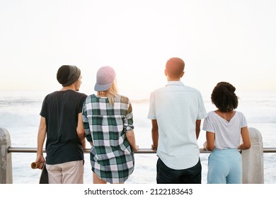 Rearview Shot Of A Group Of Young Friends Standing On The Promenade