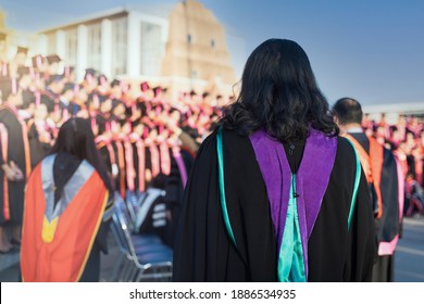 Rearview Of The University Graduates Line Up For Degree Award In University Graduation Ceremony. The University Graduates Are Gathering In The University Graduation Ceremony. Crowd Of The Graduates.