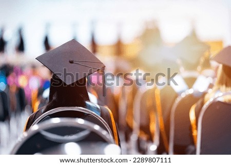 Rearview of university graduates wearing an academic gown on commencement day. Education stock photo