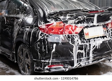 Rearview, washing the sport car with foam in the car wash shop. - Shutterstock ID 1190014786