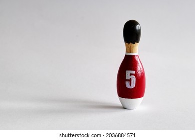 Rearview Of A Wooden Puppet In The Shape Of A Bowling Pin With A Number Five Shirt