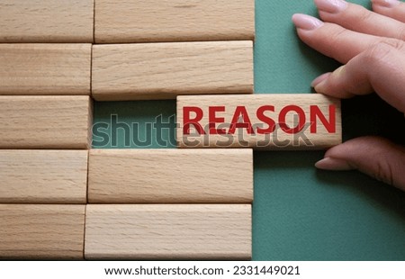Reason symbol. Concept word Reason on wooden blocks. Businessman hand. Beautiful grey green background. Business and Reason concept. Copy space.