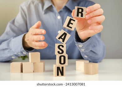 REASONS word written on wood abc block at wooden background.
