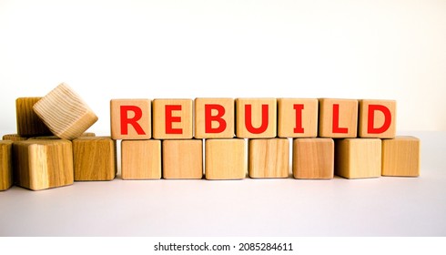 Rebuild And Build Symbol. The Concept Word Rebuild On Wooden Cubes. Beautiful White Table, White Background, Copy Space. Business Rebuild And Build Concept.