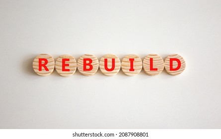 Rebuild And Build Symbol. The Concept Word Rebuild On Wooden Circles. Beautiful White Background, Copy Space. Business Rebuild And Build Concept.