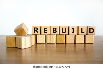 Rebuild And Build Symbol. The Concept Word Rebuild On Wooden Cubes. Beautiful Wooden Table, White Background, Copy Space. Business Rebuild And Build Concept.