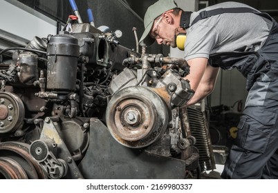 Rebuilding Heavy Duty Coach Bus Diesel Engine. Professional Caucasian Mechanic Taking Closer Look. Automotive Industry.