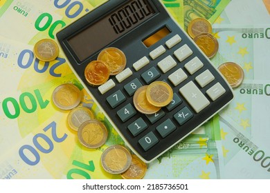 Recalculation Of Money. Expenses And Incomes In European Countries.Calculator And Euro Coins On Banknotes Background.Taxes In EU Countries.Euro Currency.Budget Allocation.