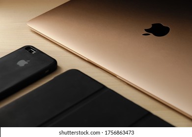 Recanati, Macerata, Italia - June 11, 2020: Family Of Apple Devices: Brand New Gold Macbook Air (2020), Thin And Light, Perfectly Portable Notebook, IPhone And IPad, On A Wooden Table, Close Up.