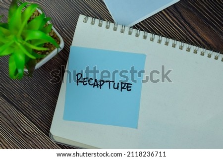 Recapture write on sticky notes isolated on Wooden Table.