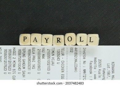 Receipt With The Word Payroll On A Small Wooden Cube