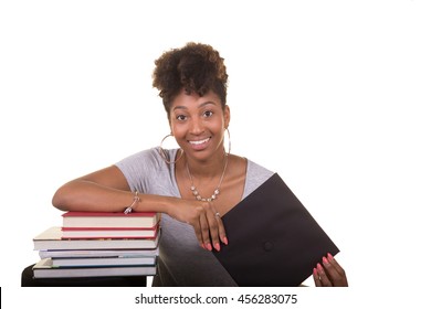 Recent College Graduate Next To A Stack Of Books