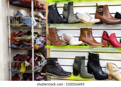 Recently made shoes at a shoes factory / workshop. They are on shelves. On the shelves at the back there are plastic pads / shoe trees and other tools for making shoes.  - Powered by Shutterstock