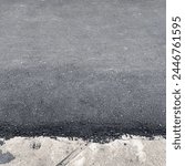 Recently renewed outdoor asphalt road way with leaked asphalt to the side walks. Rocky dark gray ground walk way photography.