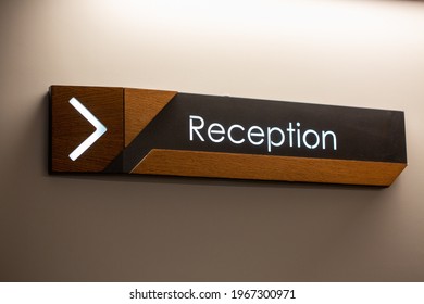 The Reception Sign With Direction Arrow On The Wall