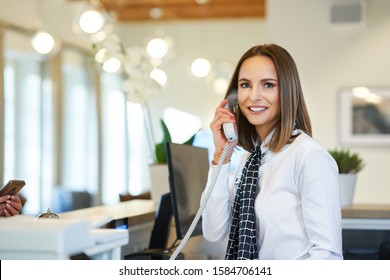 Receptionist Answering Phone At Hotel Front Desk