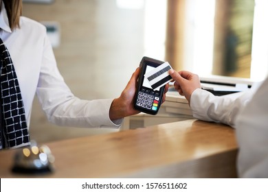 Receptionist And Businesswoman At Hotel Front Desk