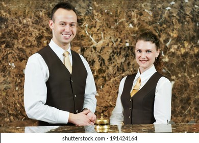 Receptionist Or Concierge Workers Standing At Hotel Counter