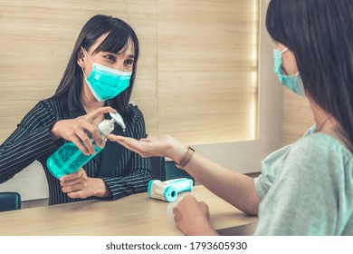 Receptionist And Guest Wearing Face Mask At Front Desk While Having Conversation In Office Or Hospital . Covid 19 And Coronavirus Infection Protection And Protective Policy Concept .