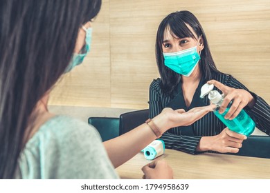 Receptionist And Guest Wearing Face Mask At Front Desk While Having Conversation In Office Or Hospital . Covid 19 And Coronavirus Infection Protection And Protective Policy Concept .