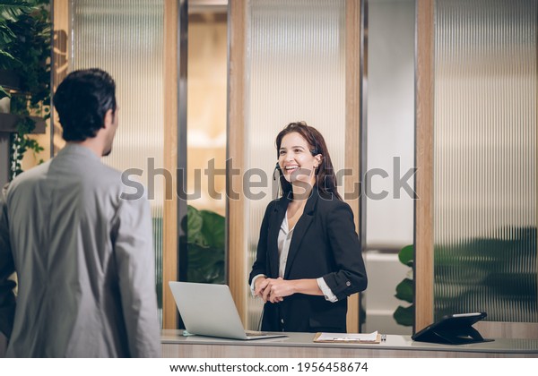 Receptionist 
at hotel front desk  welcoming at Counter
