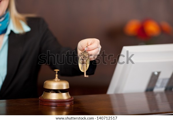 receptionist passing\
room keys over the\
counter