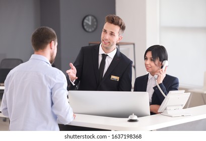 Receptionists working with visitor in office - Powered by Shutterstock