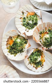 Recipe Baked Sea Scallops.  Recipe With Chopped Parsley And Dry Grated Bread  On The White Plate On The Soft Rose Marble Background, Close-up, Medium Tone. Mediterranean Seafood Recipes