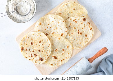 Recipe step 2. Homemade wheat tortillas, pita bread, tortilla, pita with ingredients for cooking on a white table. Top view. The concept of homemade food. - Shutterstock ID 2142507153