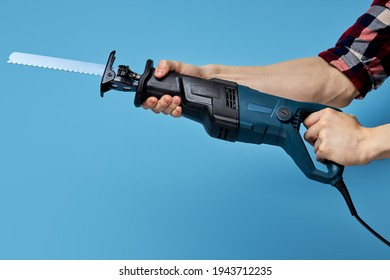 Reciprocating saw with steel toothed blade. Power tool for woodwork. isolated on blue - Shutterstock ID 1943712235