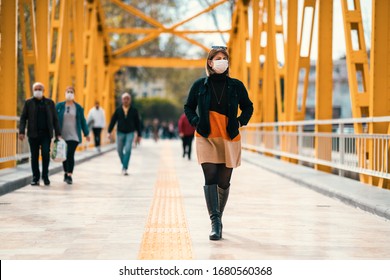 A Reckless Young Woman Walk On Crowded Street With A Mask In A Quarantine Period Because Of Pandemic Global Danger.