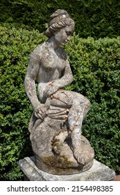 Reclaimed Weathered Composite Marble Statue Of A Sitting Female Figure On A Plinth With Wreath Reliefs