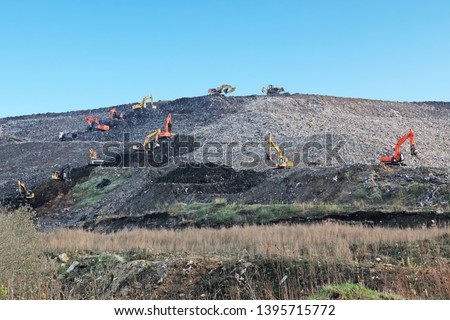 Reclamation of solid waste landfill by heavy machinery
