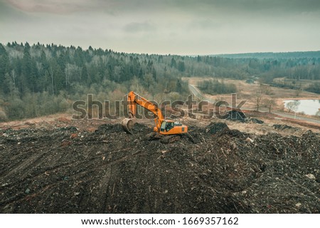 Reclamation of solid waste landfill by heavy machinery