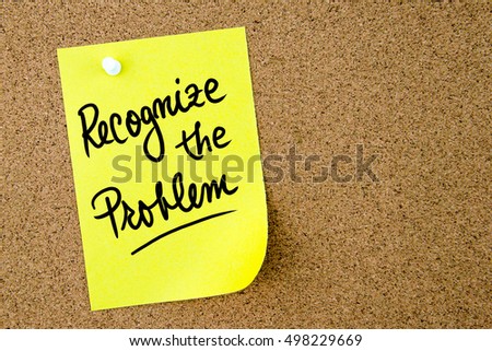 Recognize the problem text written on yellow paper note pinned on cork board with white thumbtack. Business concept image with copy space available