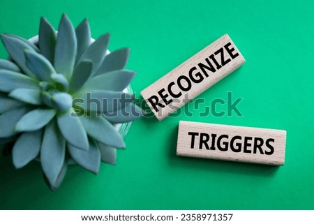 Recognize triggers symbol. Concept words Recognize triggers on wooden blocks. Beautiful green background with succulent plant. Business and Recognize triggers concept. Copy space.