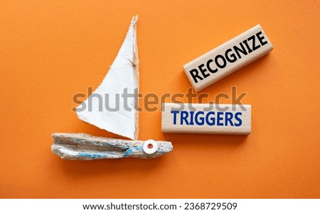 Recognize triggers symbol. Concept words Recognize triggers on wooden blocks. Beautiful orange background with boat. Business and Recognize triggers concept. Copy space.