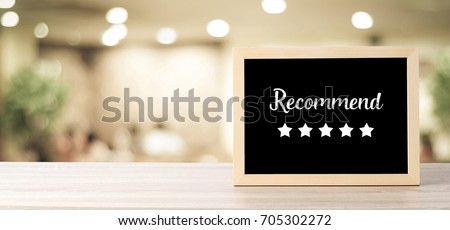 Recommend and five star on blackboard standing over blur restaurant background, copy space for text, food and drinks background, banner
