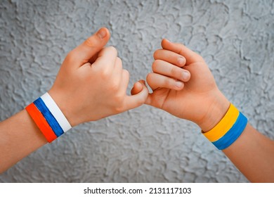 Reconciliation Concept And Handshake. Children's Hands With The Drawing Of A Flag Of Ukraine And Russia