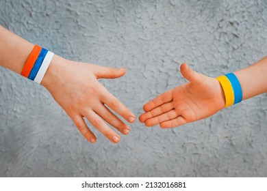 Reconciliation Concept And Handshake. Children's Hands With The Drawing Of A Flag Of Ukraine And Russia