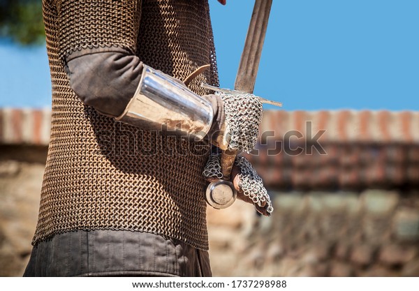 Reconquest warrior covered  with chain mail\
mittens or muffs. He is gripping the\
sword