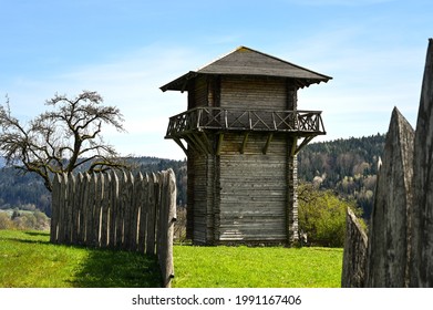 A reconstructed wooden Roman watchtower and a wooden border fence under a clear blue sky. This fortification was part of the "Limes", the border of the former Roman Empire.