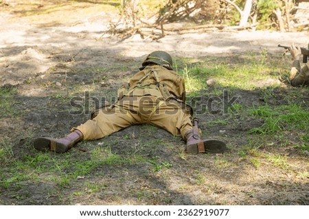 Reconstruction of battle from the Second World War. American  paratrooper soldier during combat. View from the back